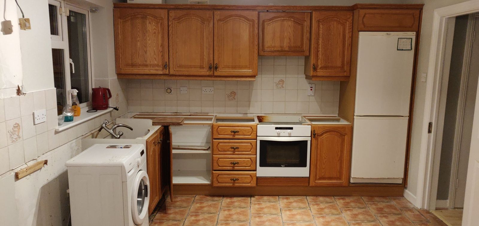 The same kitchen before, with dark oak doors and worktops removed