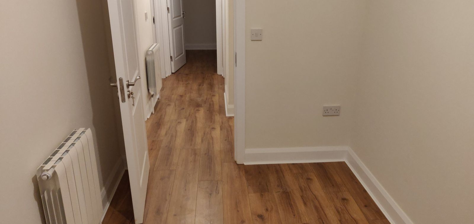 Hallway with new oak-effect laminate running into the bedrooms
