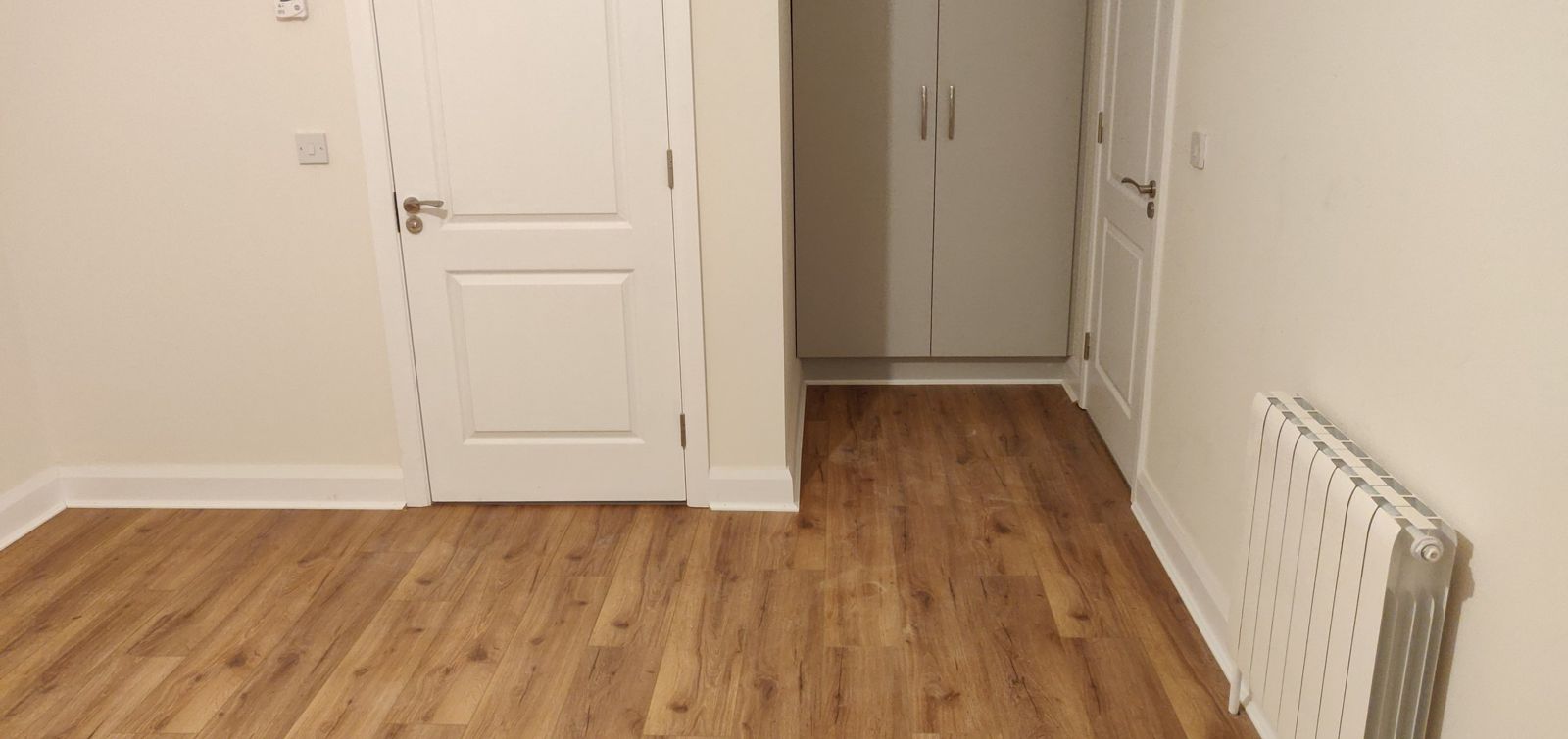 Same bedroom after: oak-effect laminate floor