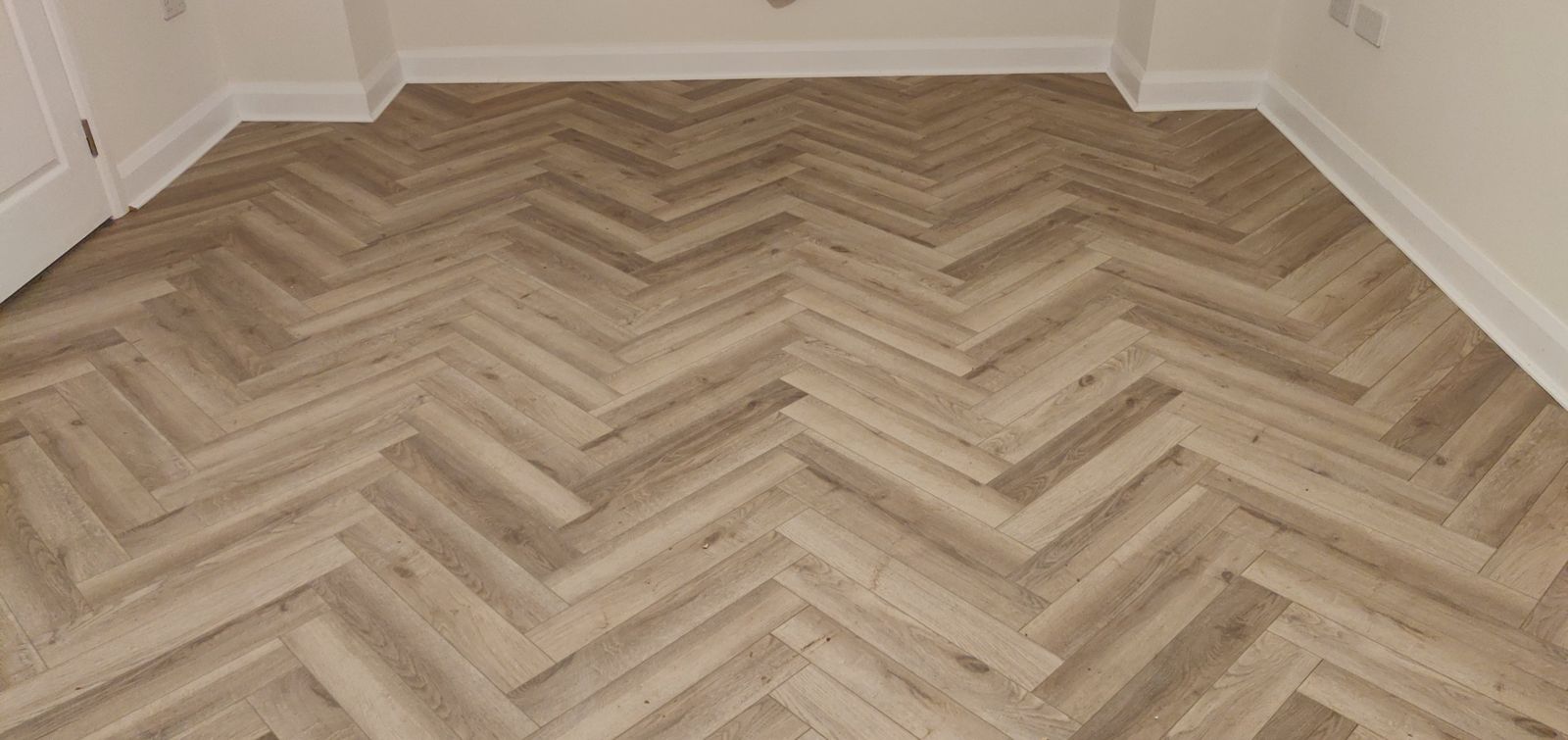 Oak-effect herringbone floor with white skirting