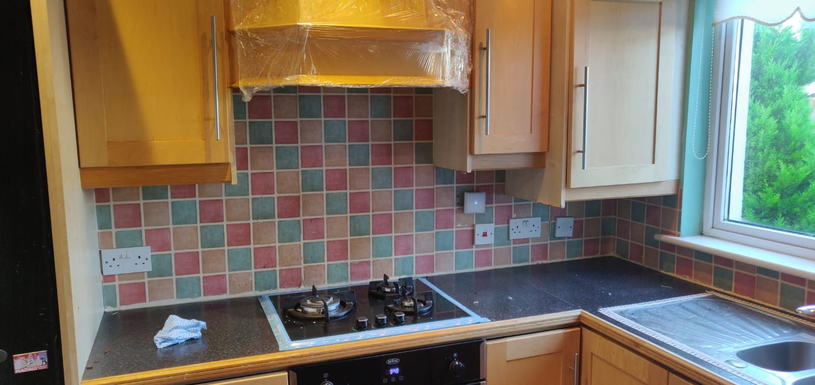 Kitchen before: old pink, green and beige splashback tiles