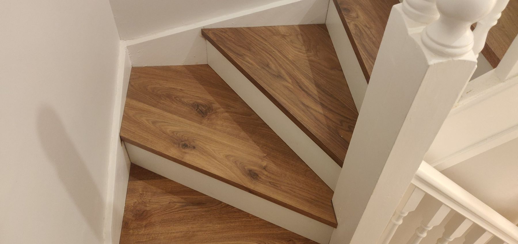 Winding staircase finished with new oak-effect treads and white risers