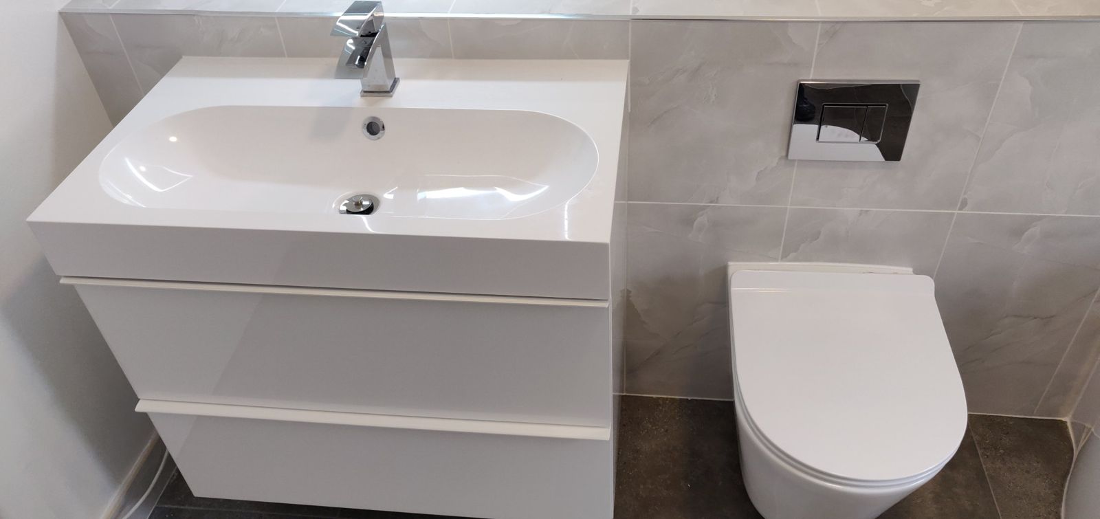 Wall-hung vanity basin and back-to-wall toilet in the refitted bathroom