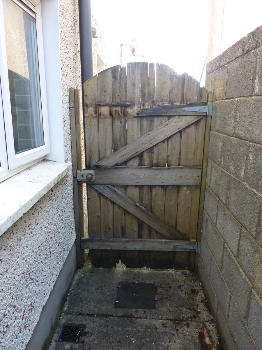 Old rotten side gate with broken boards